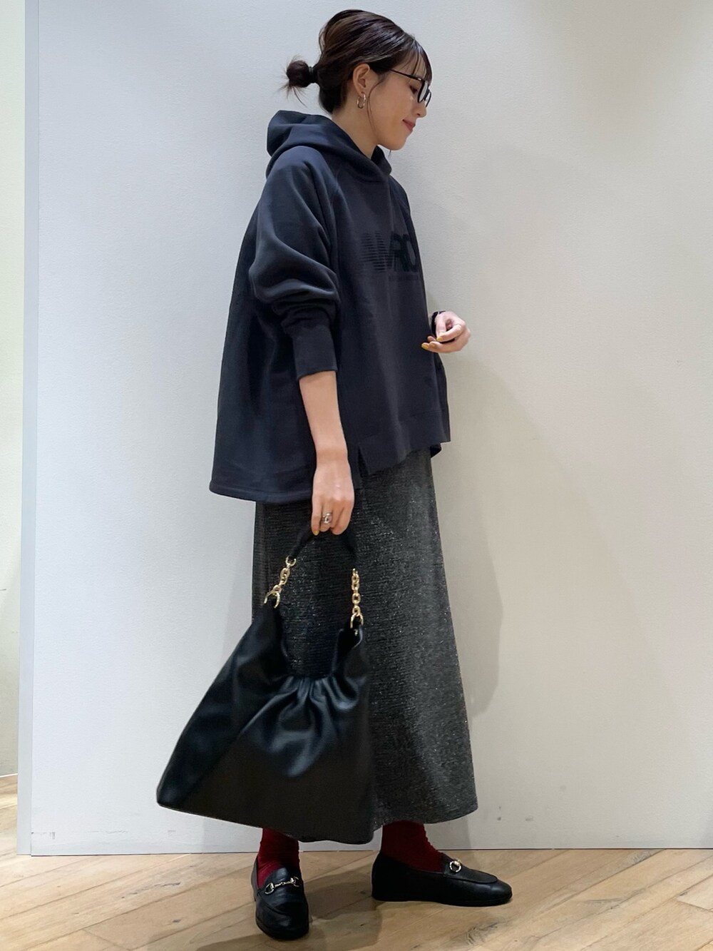 グリーン系のブルゾン、ブルー系のパーカー、シルバー系のスカートを着用したレディースの秋コーディネートの9枚目の写真