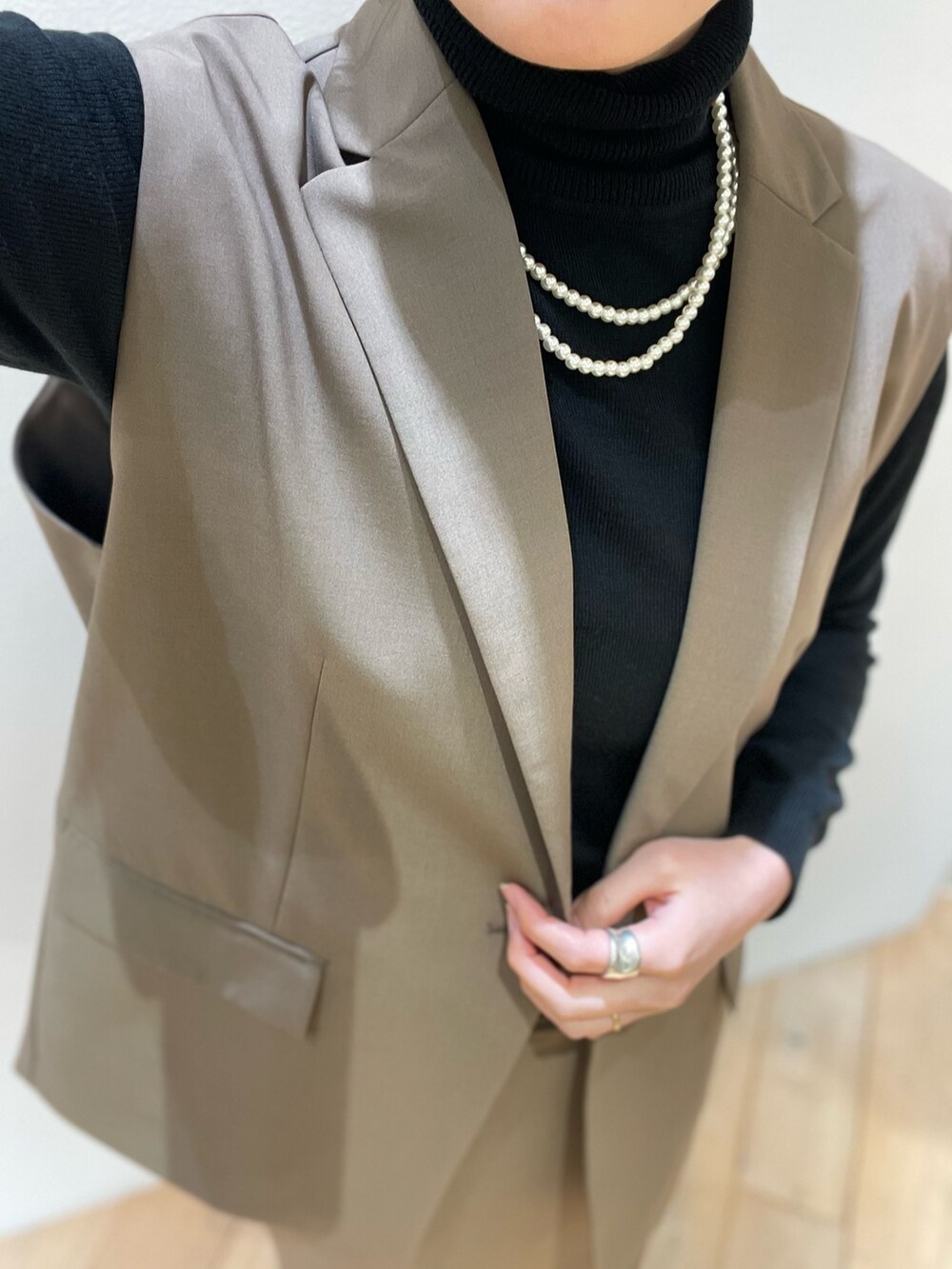 ブラウン系のベスト、ブラック系のパンプス、ブラウン系のスカートを着用したレディースの冬コーディネートの7枚目の写真