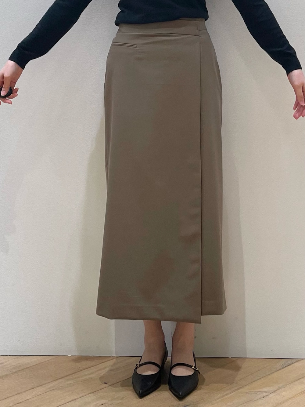 ブラウン系のベスト、ブラック系のパンプス、ブラウン系のスカートを着用したレディースの冬コーディネートの10枚目の写真