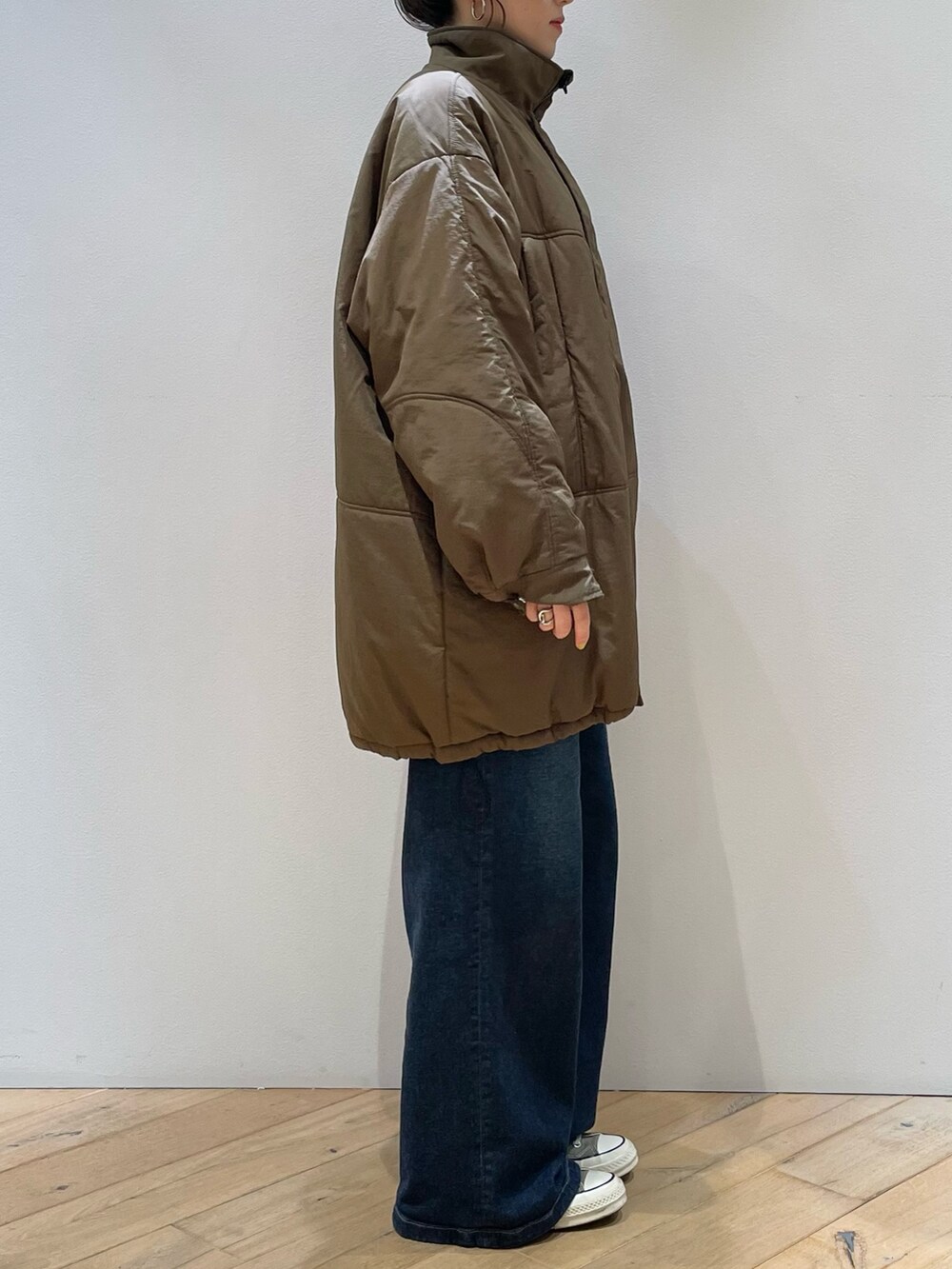 ブラウン系のダウンジャケット/コート、ブラウン系のショルダーバッグ、レッド系のニット/セーターを着用したレディースの冬コーディネートの5枚目の写真