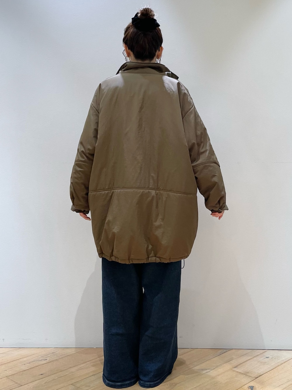 ブラウン系のダウンジャケット/コート、ブラウン系のショルダーバッグ、レッド系のニット/セーターを着用したレディースの冬コーディネートの3枚目の写真