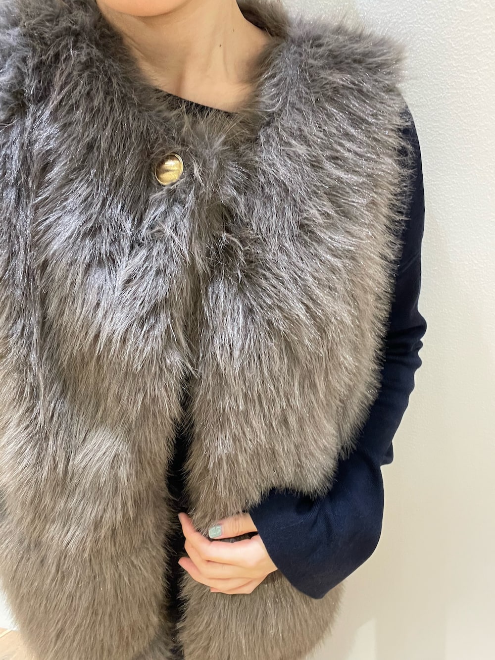 ブラウン系のベスト、ブルー系のニット/セーター、ブルー系のスカートを着用したレディースの秋コーディネートの7枚目の写真