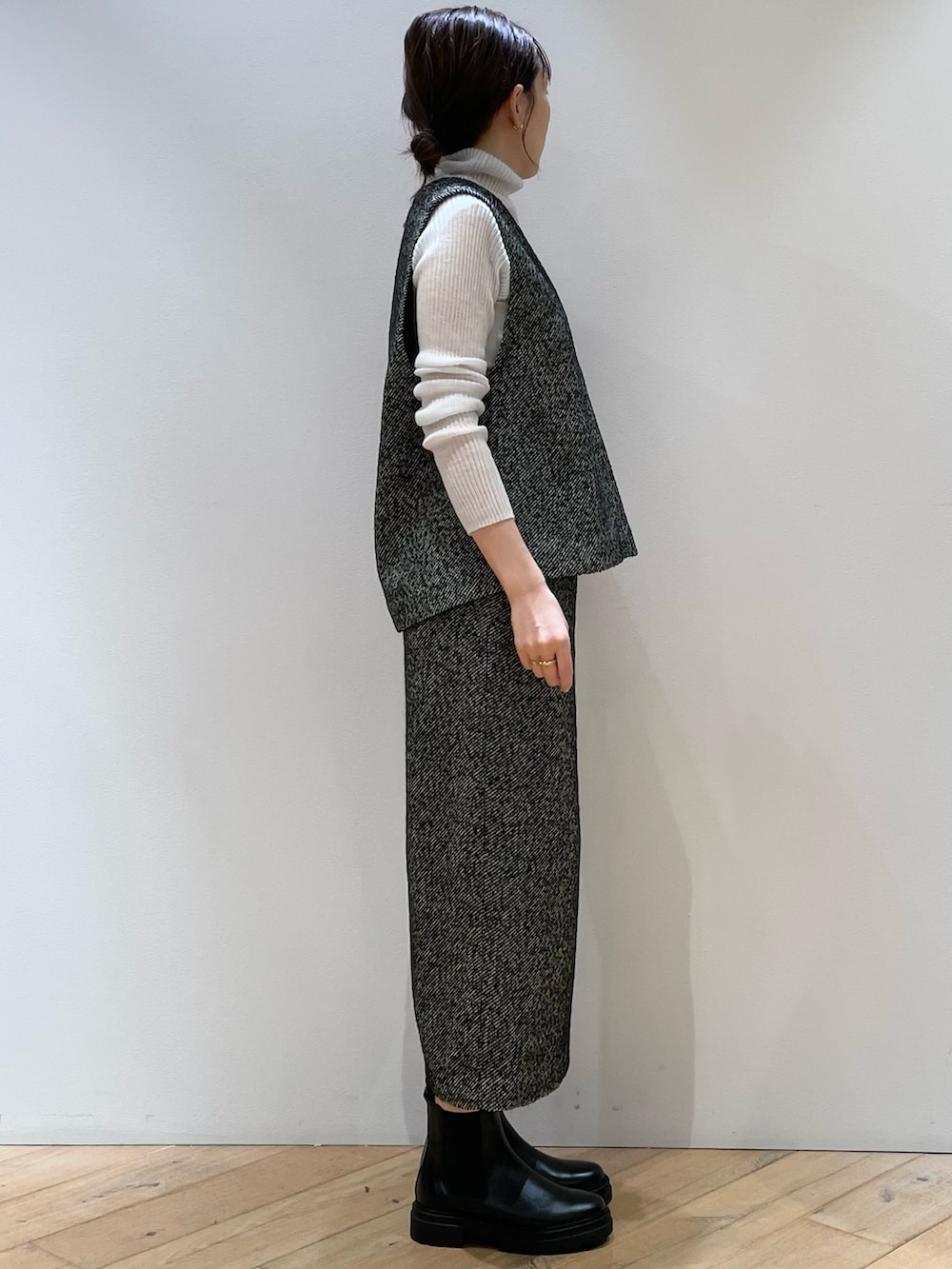 ブラック系のスカート、ブラック系のベスト、グレー系のニット/セーターを着用したレディースの秋コーディネートの2枚目の写真