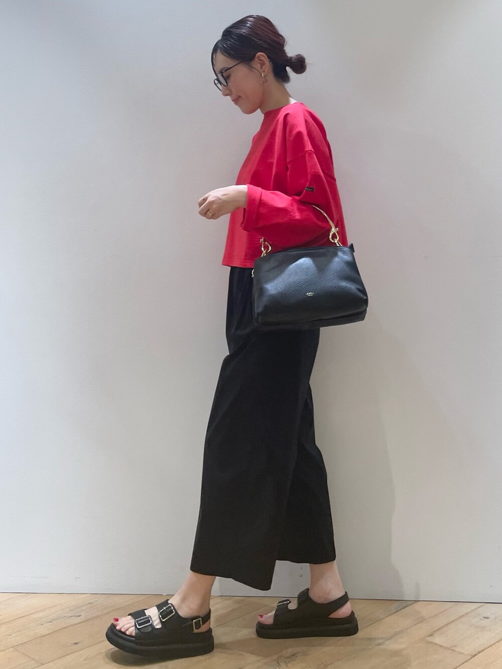 レッド系のTシャツ/カットソー、ブラック系のその他パンツ、ブラック系のショルダーバッグを着用したレディースの夏コーディネートの7枚目の写真