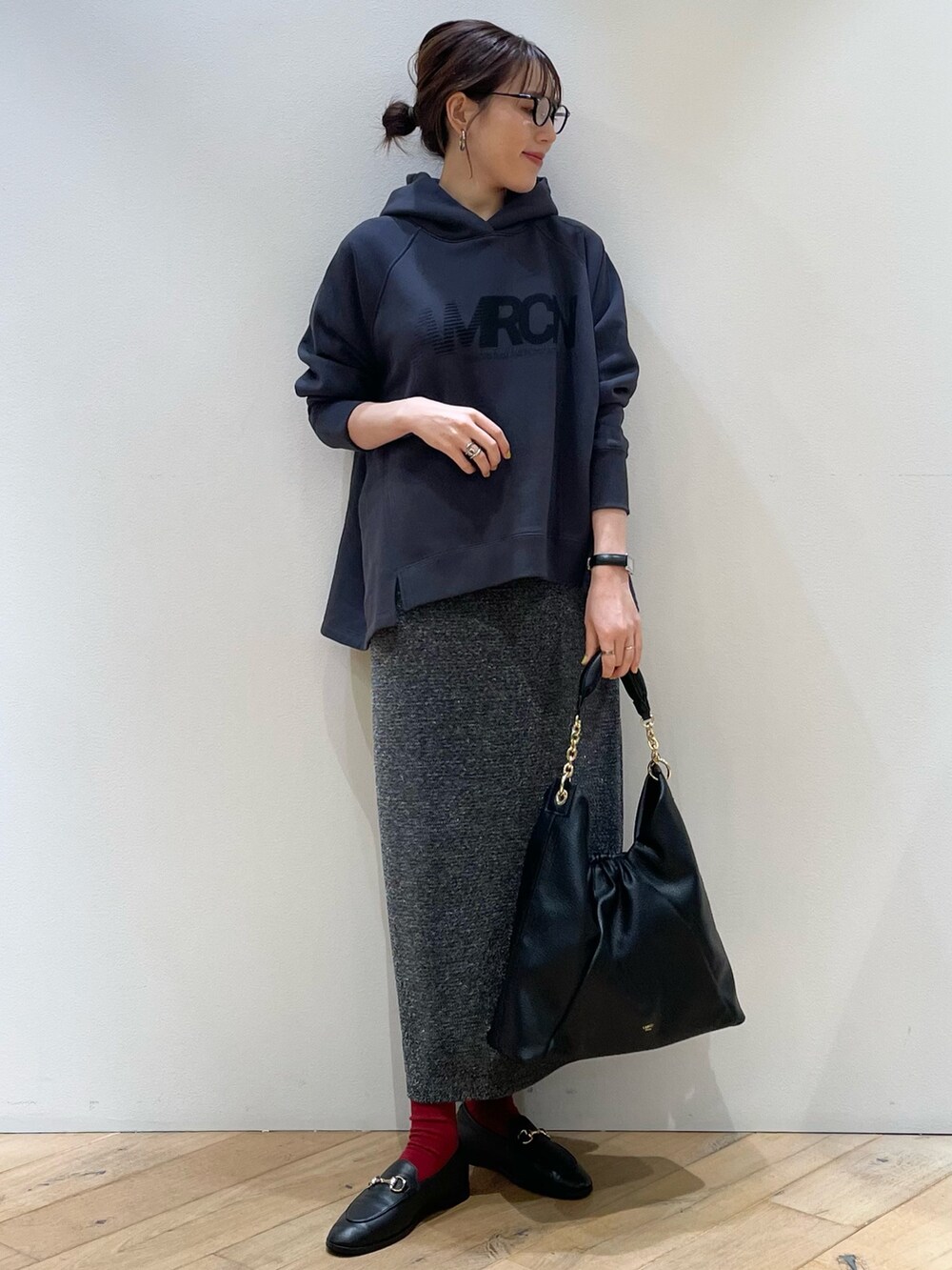 グリーン系のブルゾン、ブルー系のパーカー、シルバー系のスカートを着用したレディースの秋コーディネートの7枚目の写真