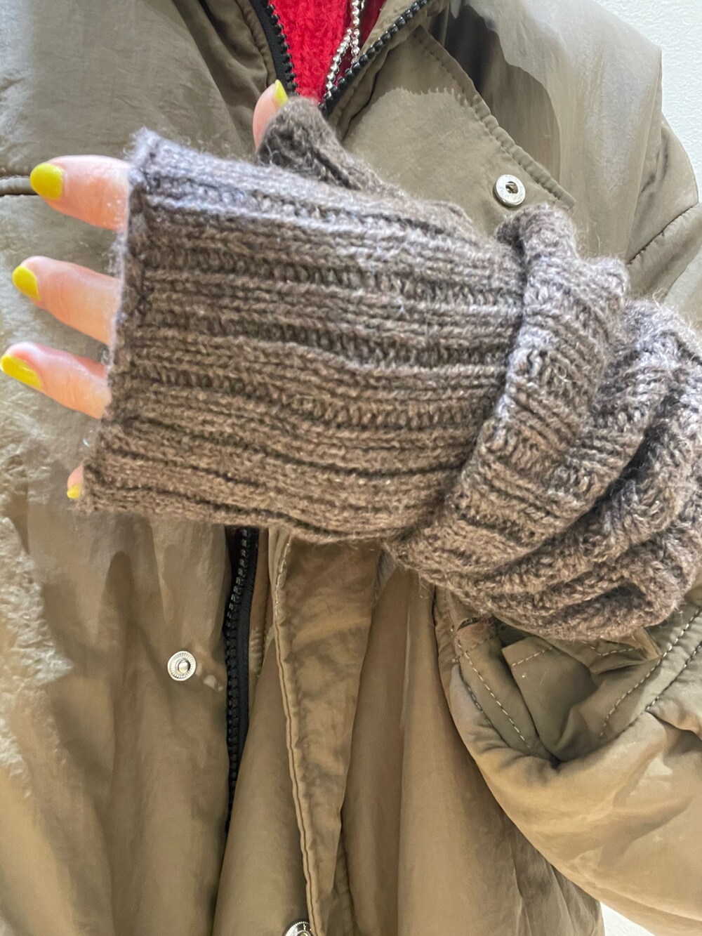 ブラウン系のダウンジャケット/コート、ブラウン系のショルダーバッグ、レッド系のニット/セーターを着用したレディースの冬コーディネートの8枚目の写真