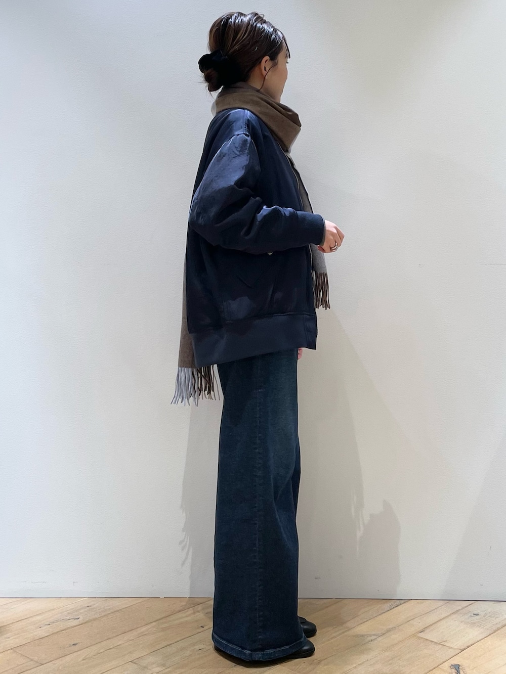 ブラウン系のボストンバッグ、ブラック系のローファー、ブルー系のデニムパンツを着用したレディースの秋コーディネートの5枚目の写真