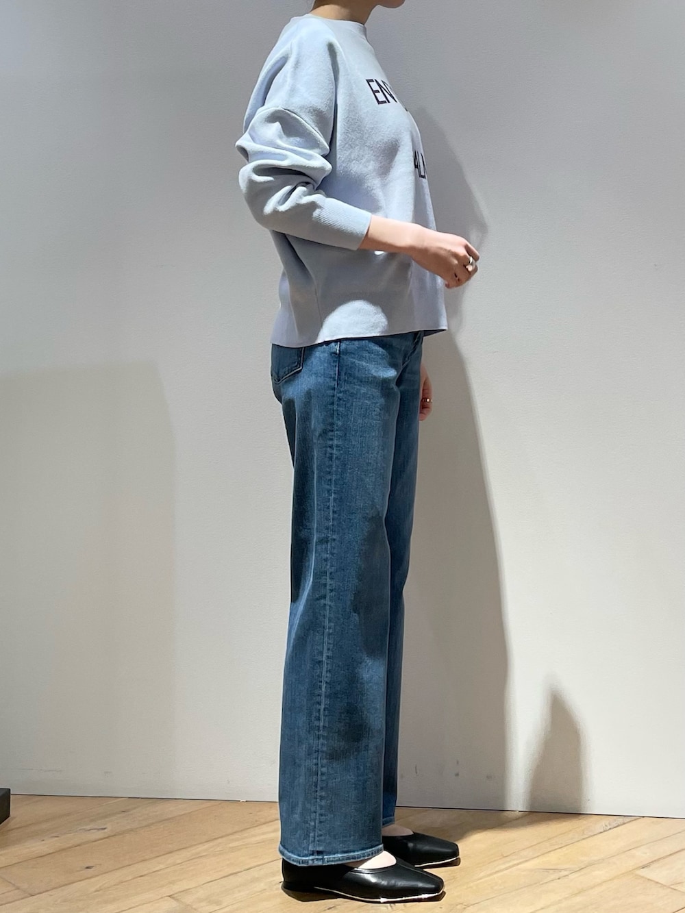 ブラック系のパンプス、ブルー系のトートバッグ、グレー系のシャツ/ブラウスを着用したレディースの春コーディネートの2枚目の写真