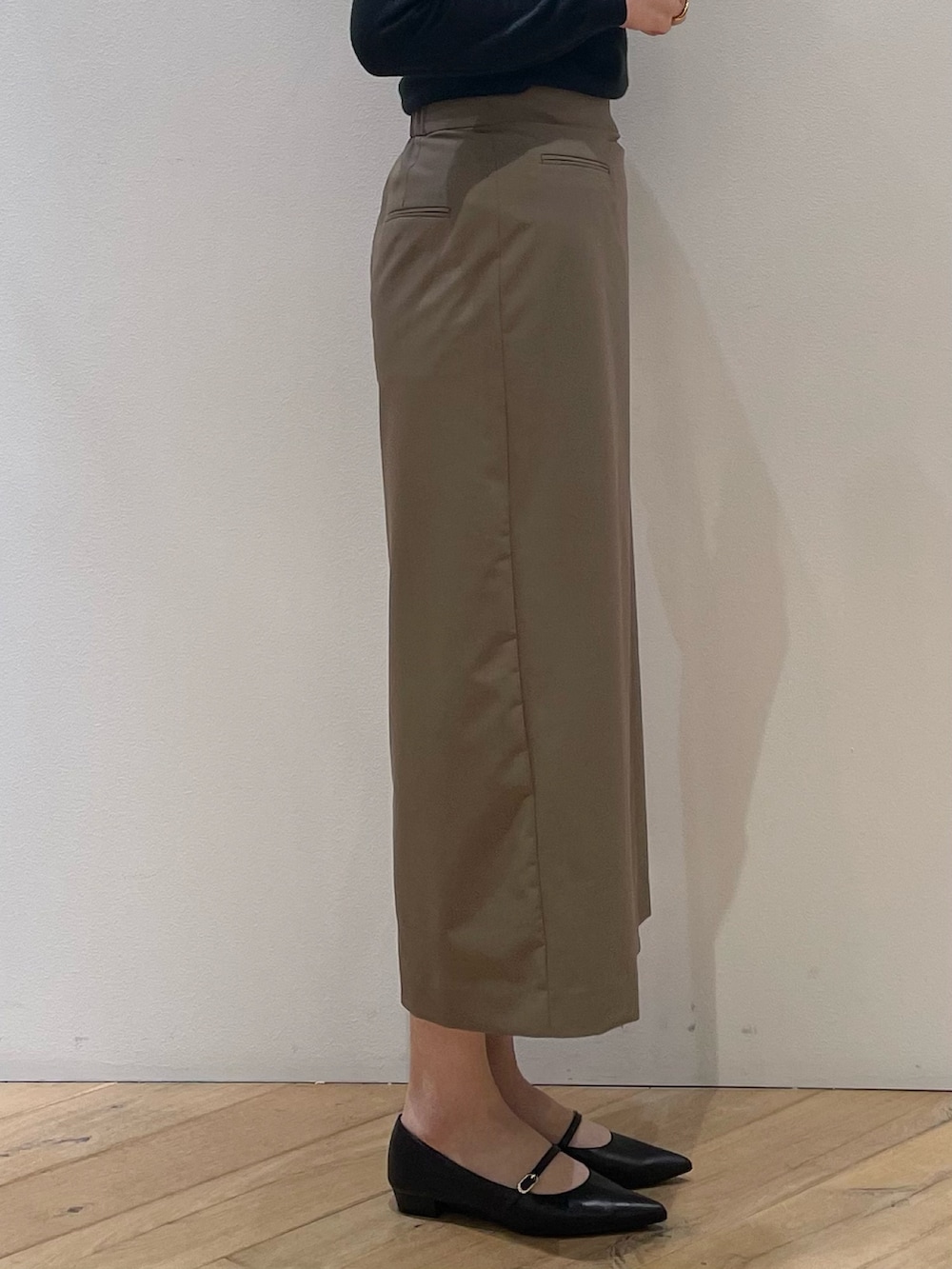 ブラウン系のベスト、ブラック系のパンプス、ブラウン系のスカートを着用したレディースの冬コーディネートの9枚目の写真