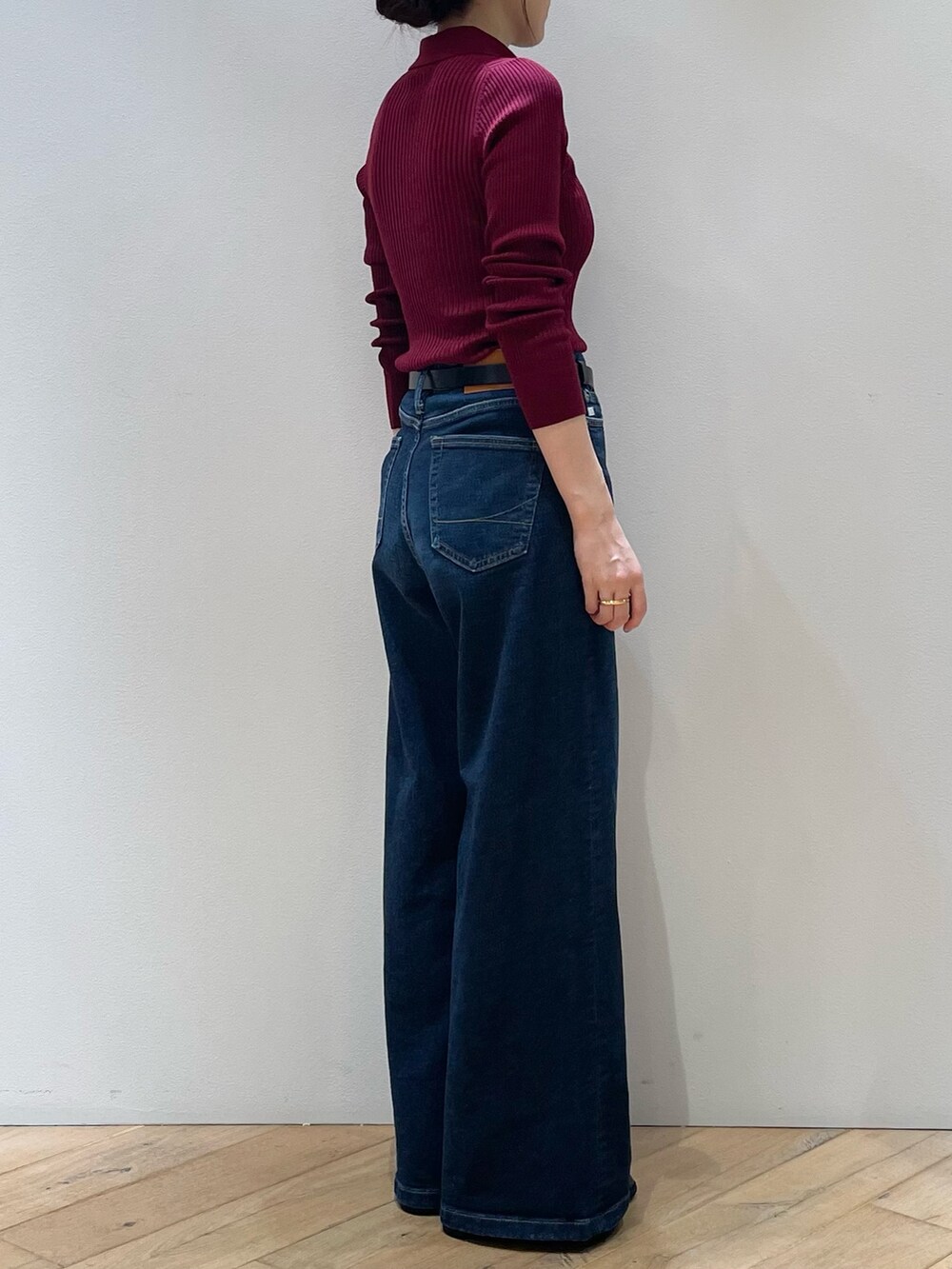 レッド系のニット/セーター、ブルー系のデニムパンツ、ブラック系のローファーを着用したレディースの秋コーディネートの3枚目の写真