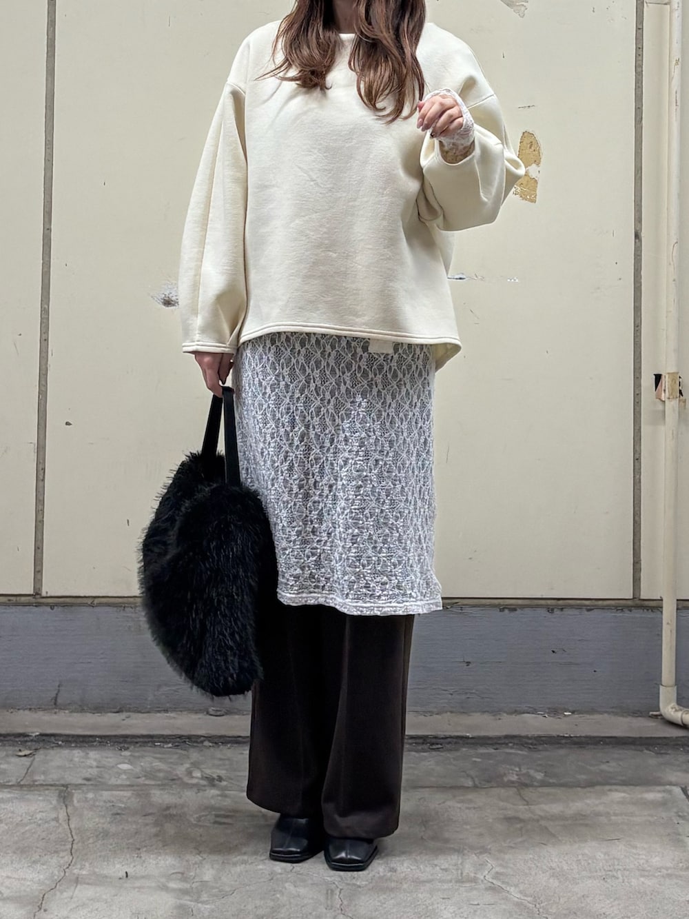 ホワイト系のTシャツ/カットソー、ブラウン系のスラックス、ブラック系のブーツを着用したレディースの冬コーディネートの3枚目の写真