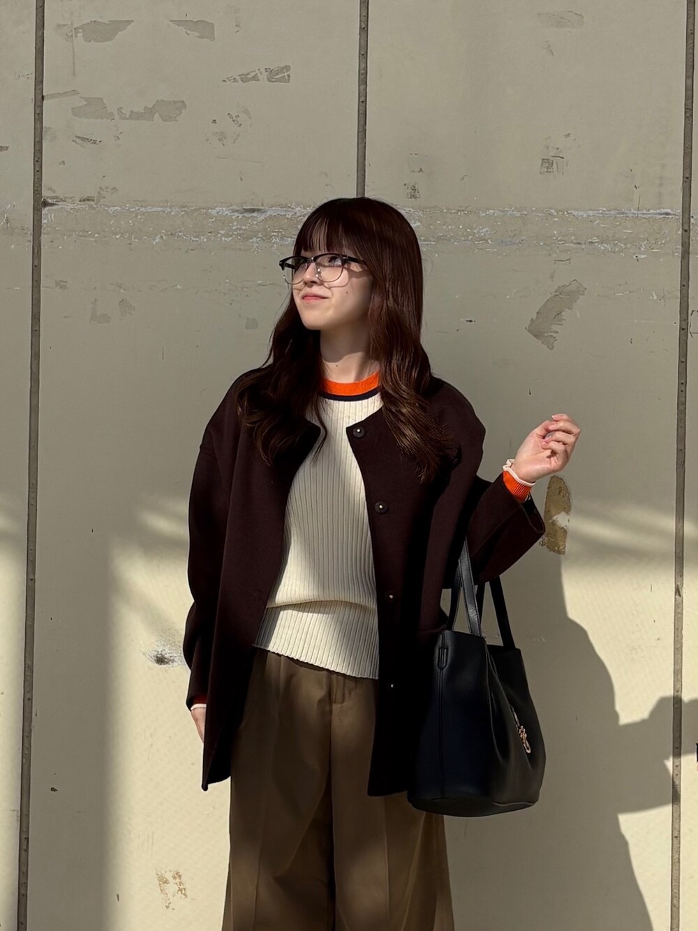 ホワイト系のニット/セーター、ブラウン系のその他アウター、ベージュ系のその他パンツを着用したレディースの秋コーディネートの2枚目の写真