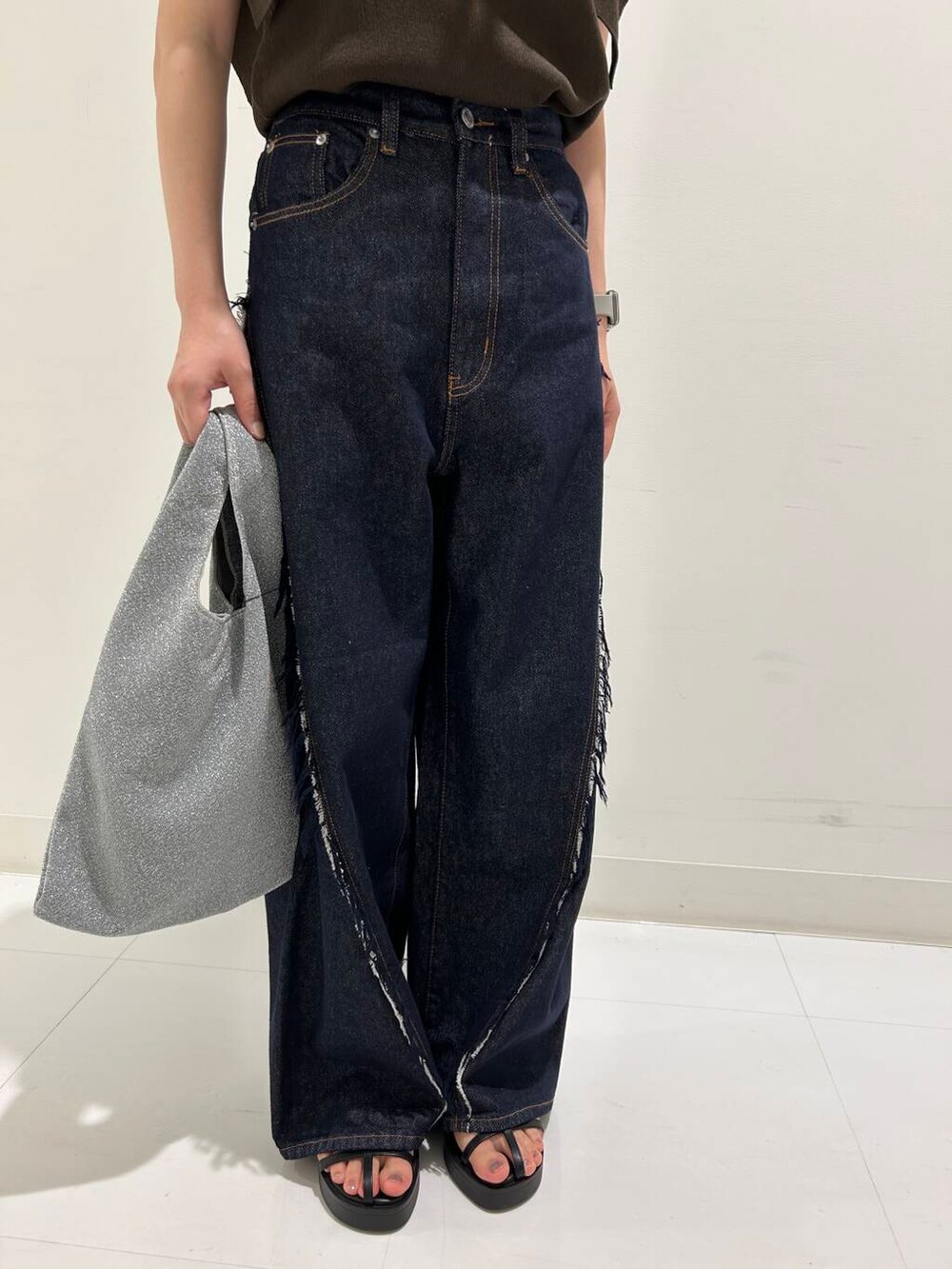 ブルー系のデニムパンツ、ブラック系のサンダル、ブラウン系のニット/セーターを着用したレディースの夏コーディネートの3枚目の写真