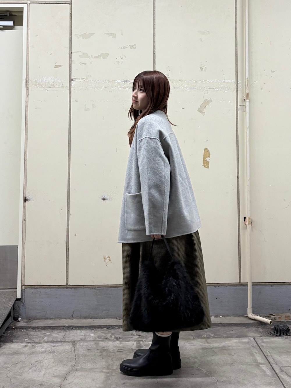 グレー系のその他アウター、ブラウン系のワンピース、ブラック系のハンドバッグを着用したレディースの秋コーディネートの2枚目の写真