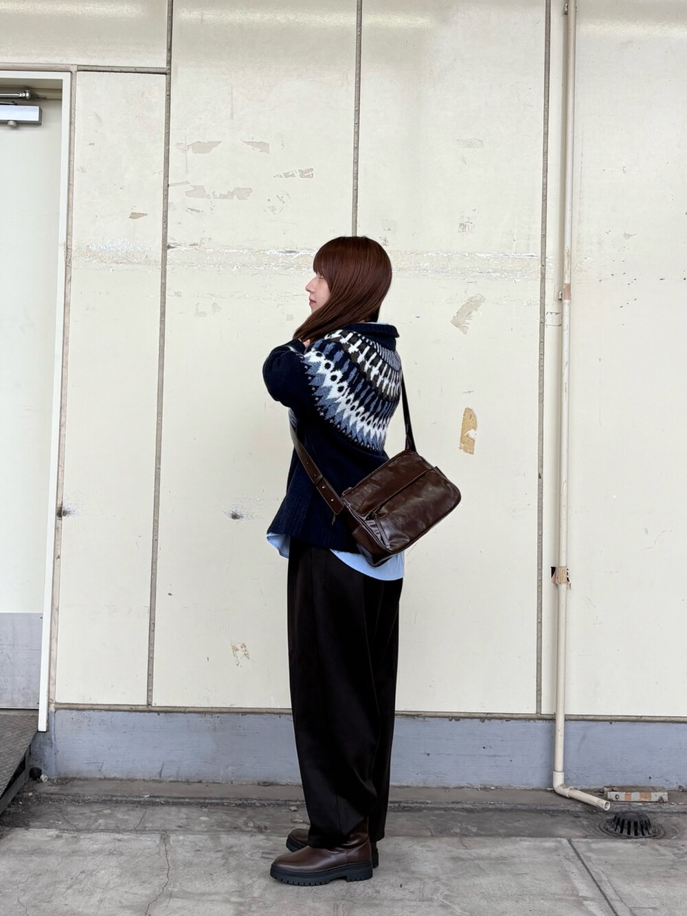 ブルー系のニット/セーター、ブルー系のシャツ/ブラウス、ブラウン系のショルダーバッグを着用したレディースの秋コーディネートの2枚目の写真