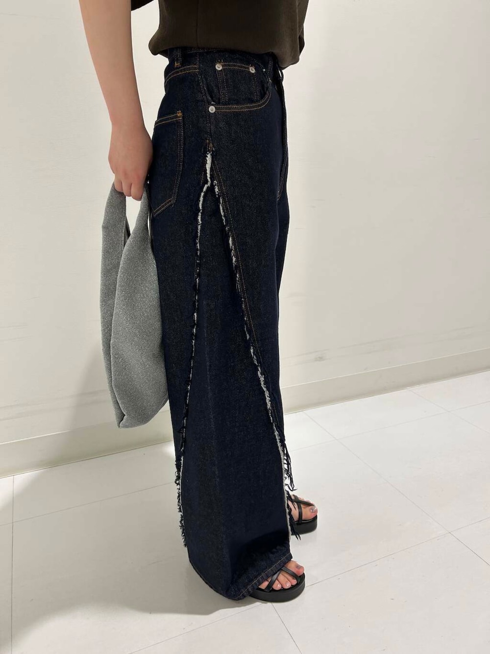 ブルー系のデニムパンツ、ブラック系のサンダル、ブラウン系のニット/セーターを着用したレディースの夏コーディネートの4枚目の写真