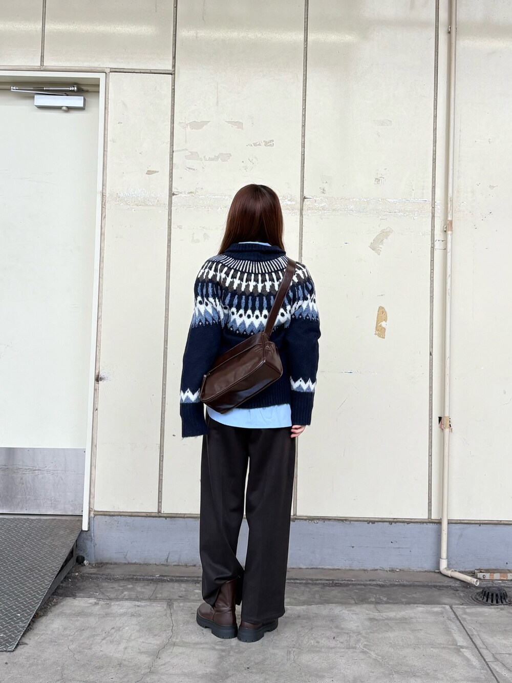 ブルー系のニット/セーター、ブルー系のシャツ/ブラウス、ブラウン系のショルダーバッグを着用したレディースの秋コーディネートの3枚目の写真