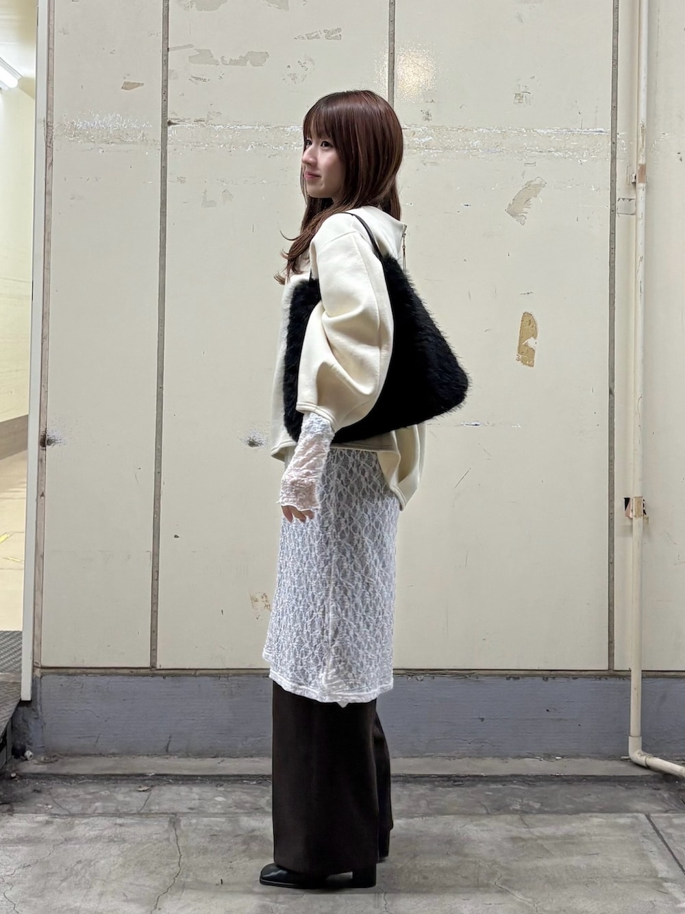 ホワイト系のTシャツ/カットソー、ブラウン系のスラックス、ブラック系のブーツを着用したレディースの冬コーディネートの2枚目の写真