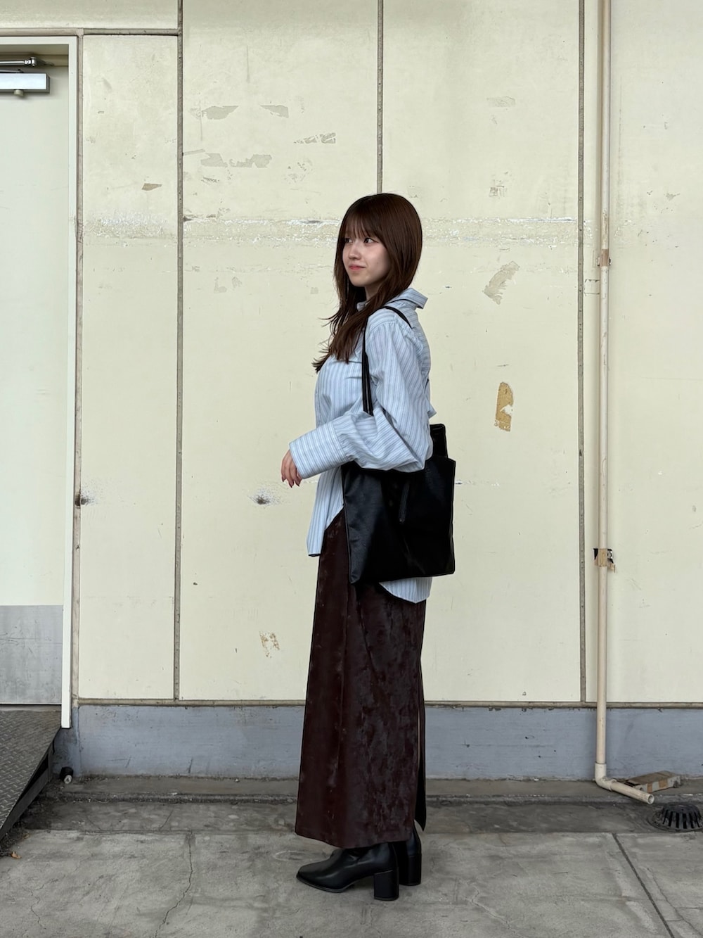 ブルー系のシャツ/ブラウス、ブラック系のブーツ、ブラウン系のスカートを着用したレディースの秋コーディネートの2枚目の写真