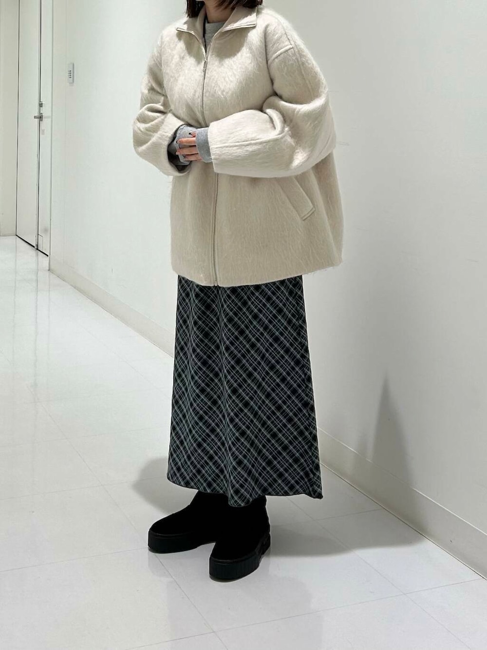 ブラック系のブーツ、グレー系のスウェット、グレー系のスカートを着用したレディースの冬コーディネートの2枚目の写真