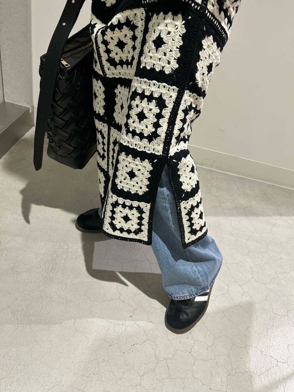 ブルー系のデニムパンツ、ホワイト系のTシャツ/カットソー、ブラック系のトートバッグを着用したレディースの夏コーディネートの2枚目の写真