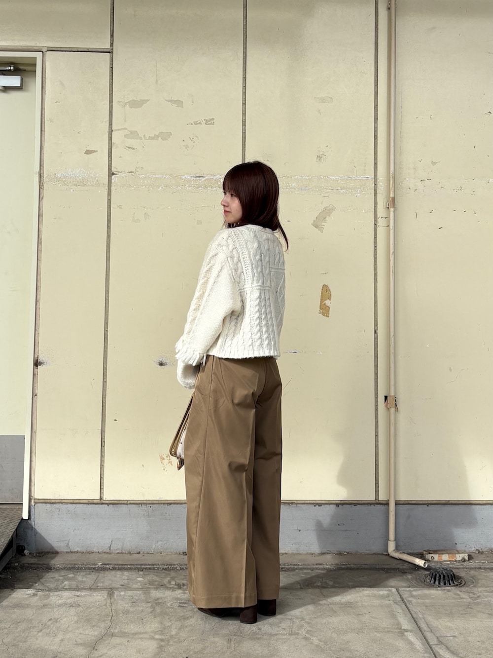 ホワイト系のカーディガン/ボレロ、ベージュ系のその他パンツ、ベージュ系のショルダーバッグを着用したレディースの秋コーディネートの2枚目の写真