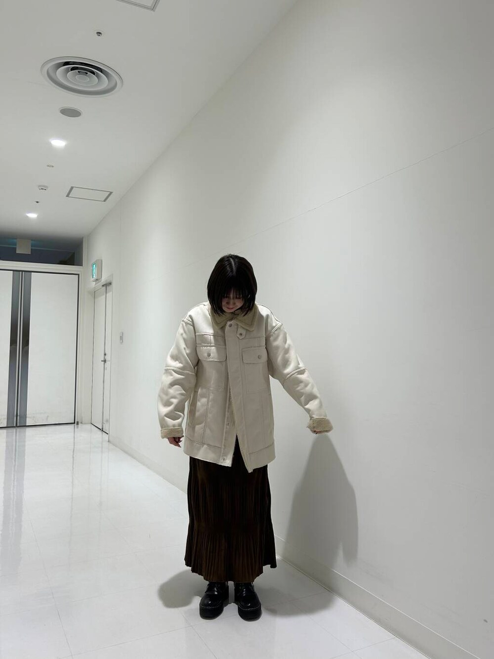 ホワイト系のその他アウター、ブラウン系のワンピース、ホワイト系のスウェットを着用したレディースの冬コーディネートの2枚目の写真