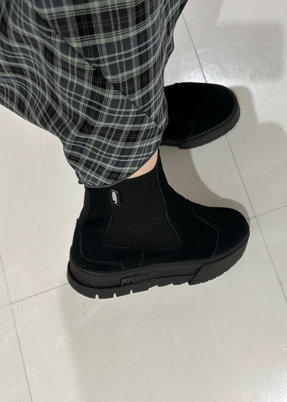 ブラック系のブーツ、グレー系のスウェット、グレー系のスカートを着用したレディースの冬コーディネートの3枚目の写真