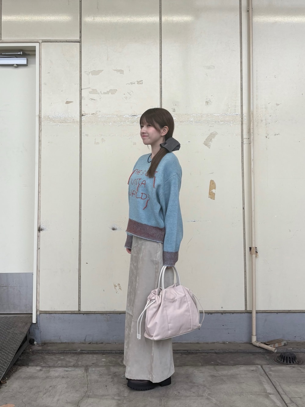 ブルー系のニット/セーター、ブラウン系のブーツ、ベージュ系のスカートを着用したレディースの秋コーディネートの2枚目の写真