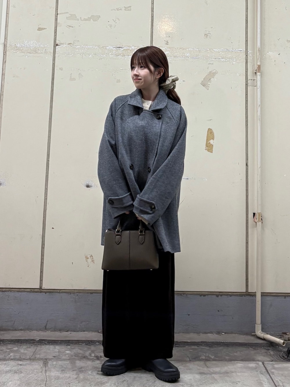 ベージュ系のカーディガン/ボレロ、ブラック系のブーツ、ブラウン系のトートバッグを着用したレディースの秋コーディネートの2枚目の写真