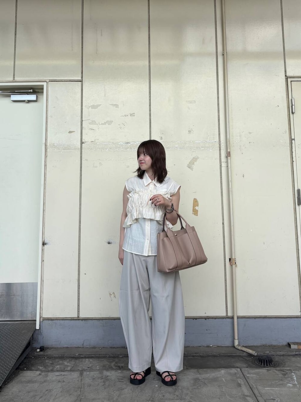ベージュ系のトートバッグ、ホワイト系のシャツ/ブラウス、ベージュ系のその他パンツを着用したレディースの夏コーディネートの2枚目の写真