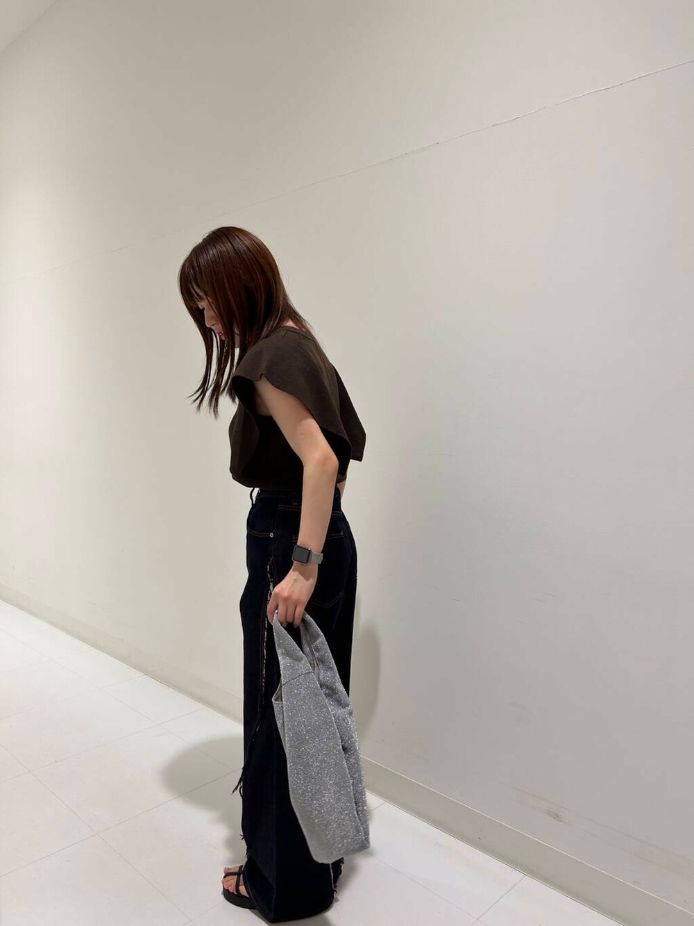 ブルー系のデニムパンツ、ブラック系のサンダル、ブラウン系のニット/セーターを着用したレディースの夏コーディネートの2枚目の写真