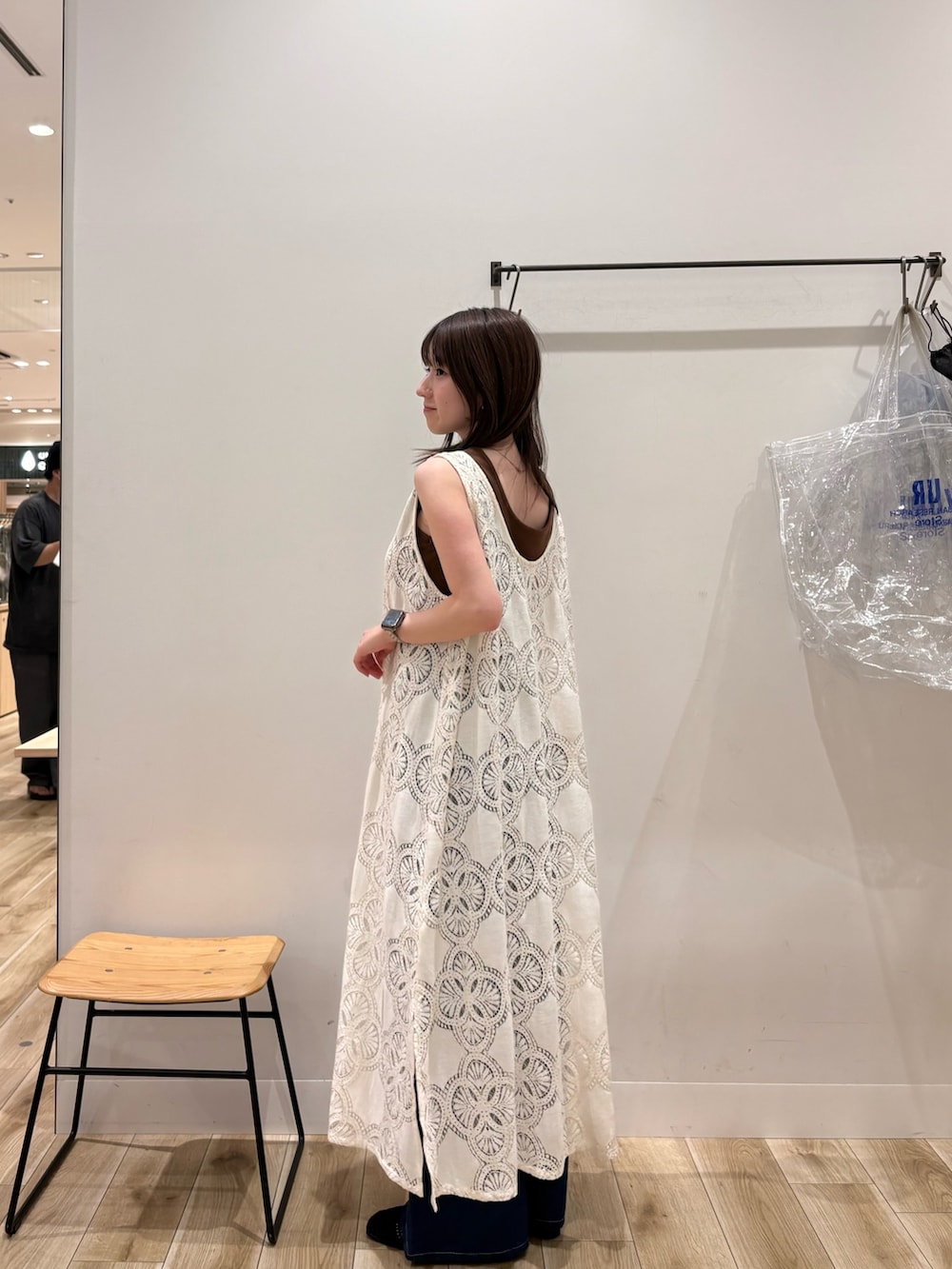 ブラウン系のタンクトップ、ホワイト系のワンピース、ブルー系のデニムパンツを着用したレディースの夏コーディネートの2枚目の写真