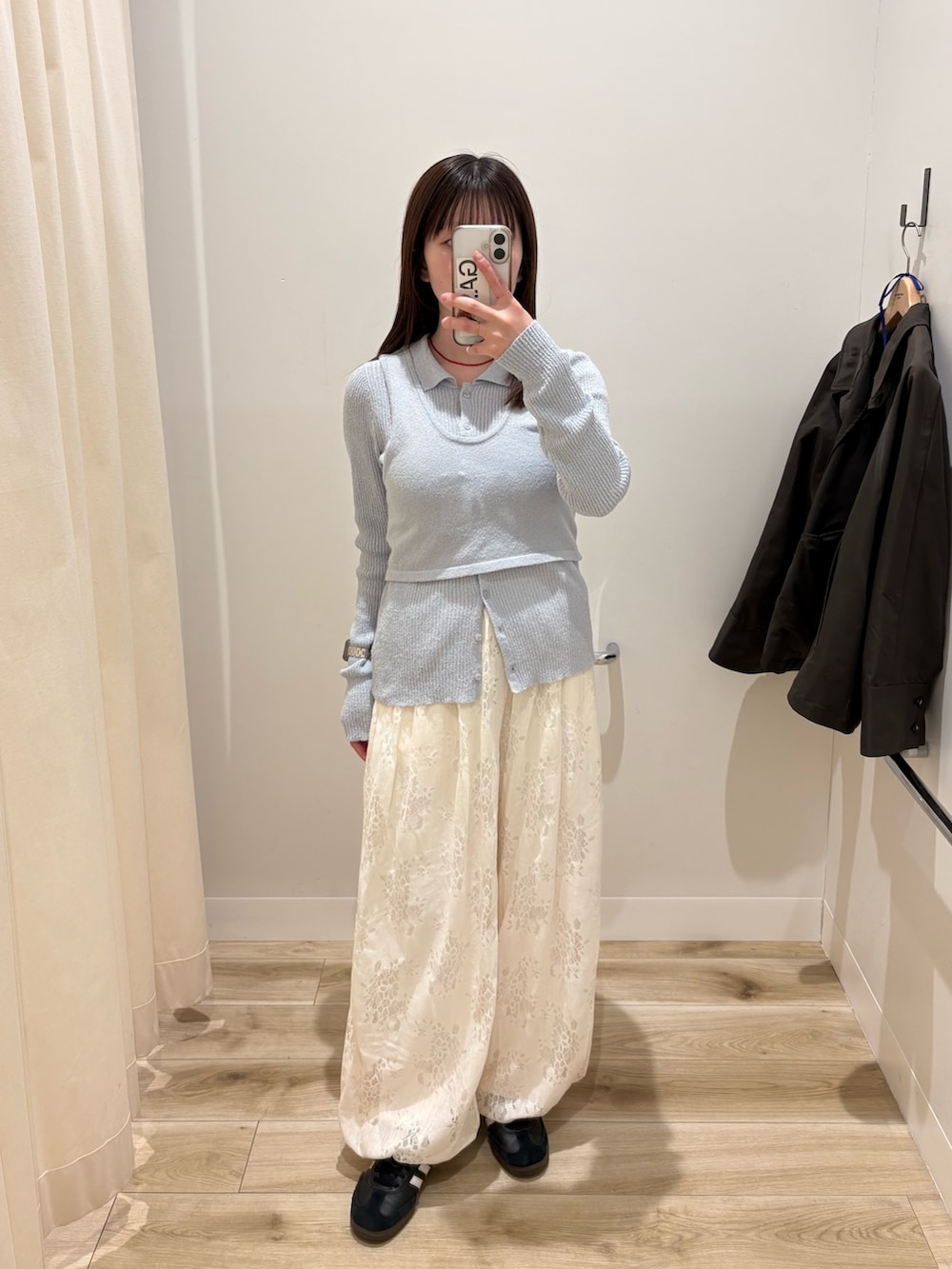 ブルー系のニット/セーター、ホワイト系のその他パンツ、グレー系のステンカラーコートを着用したレディースの冬コーディネートの2枚目の写真