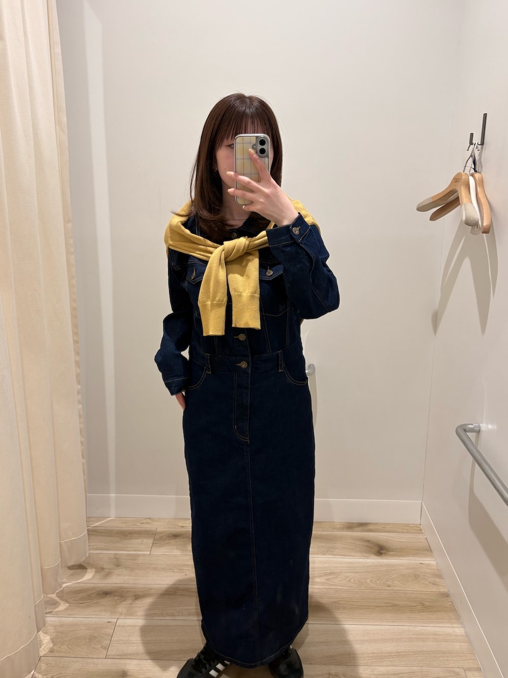 ブルー系のワンピース、イエロー系のニット/セーターを着用したレディースの春コーディネートの2枚目の写真