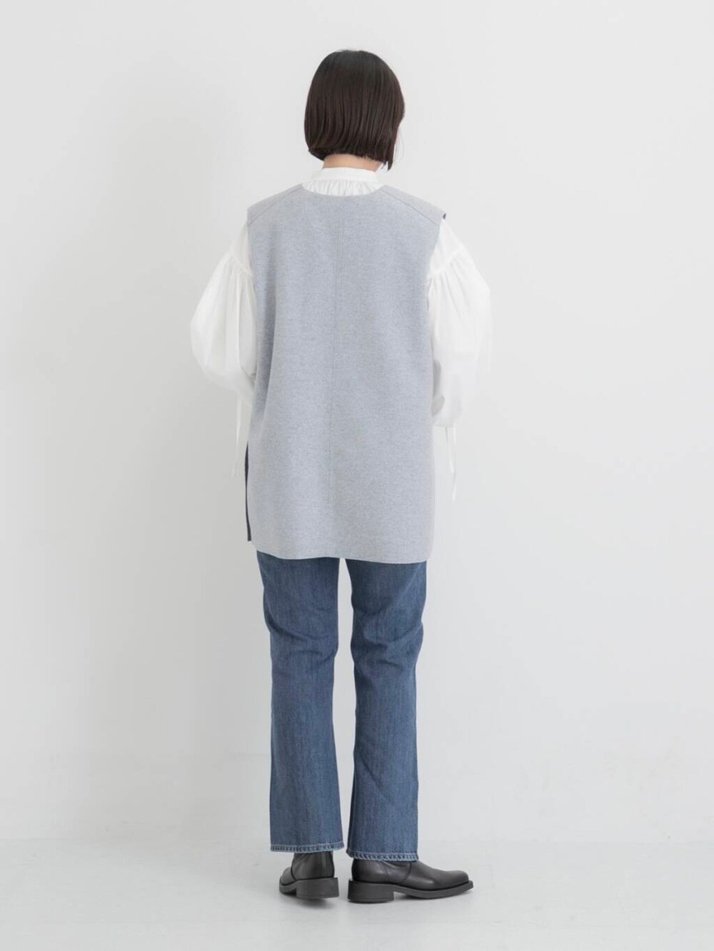 ブルー系のデニムパンツ、ホワイト系のシャツ/ブラウス、グレー系のベストを着用したレディースの秋コーディネートの4枚目の写真