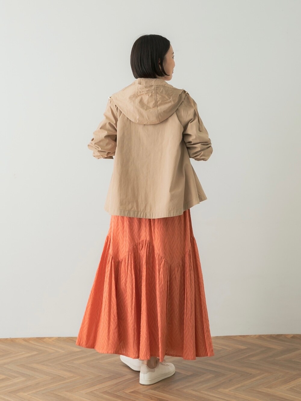 ホワイト系のTシャツ/カットソー、レッド系のスカート、ベージュ系のマウンテンパーカーを着用したレディースの夏コーディネートの3枚目の写真