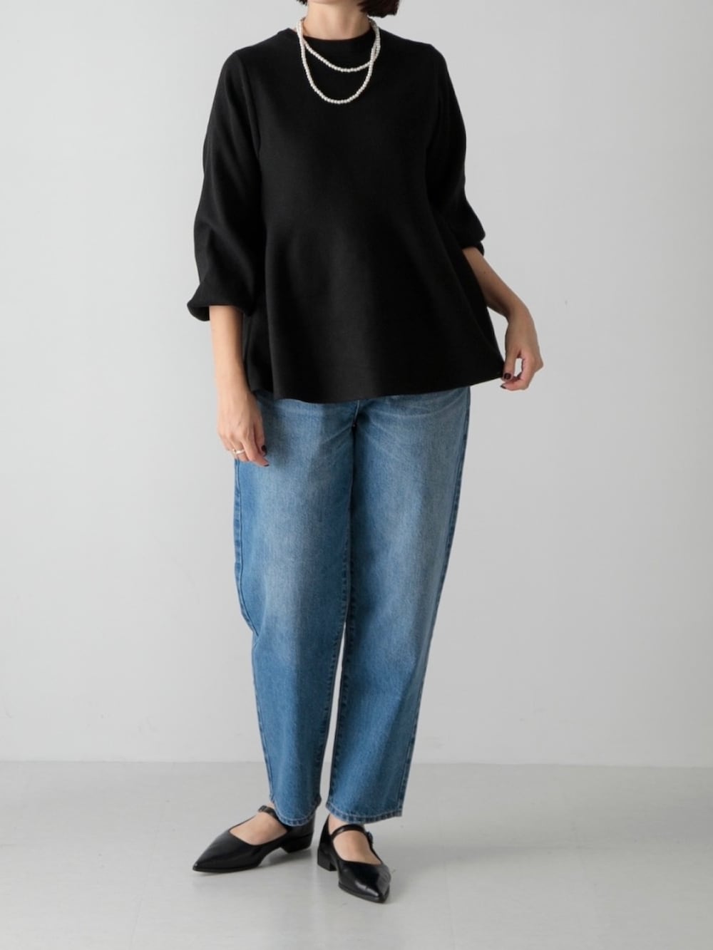 ブラック系のニット/セーター、ブルー系のデニムパンツ、ブラック系のその他シューズを着用したレディースの秋コーディネートの2枚目の写真