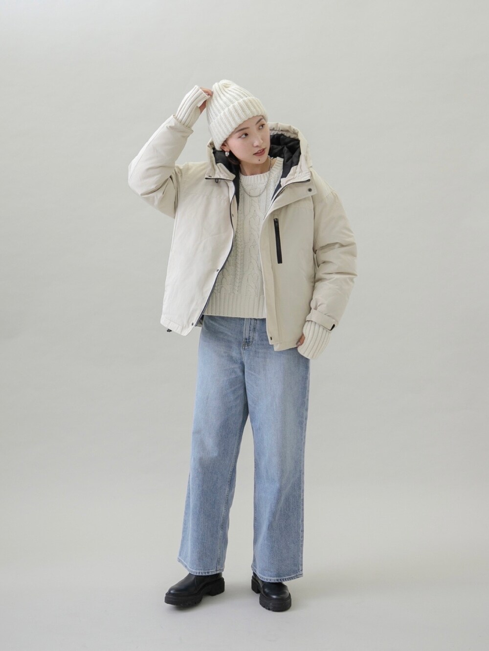 ベージュ系のダウンジャケット/コート、ブルー系のデニムパンツ、ブラック系のブーツを着用したレディースの秋コーディネートの5枚目の写真