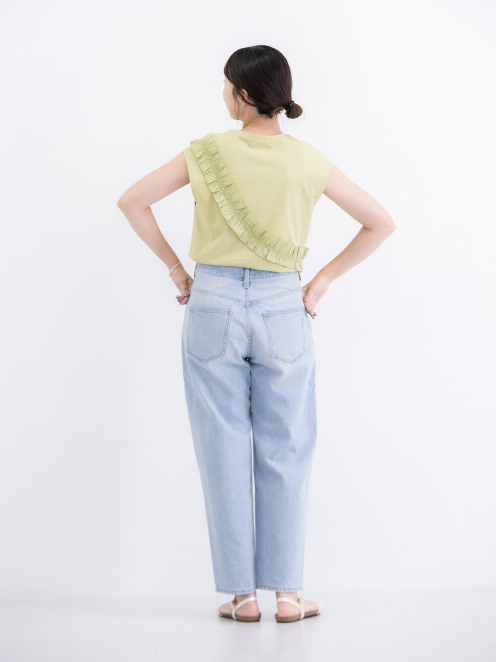 グリーン系のTシャツ/カットソー、ブルー系のデニムパンツ、ゴールド系のサンダルを着用したレディースの夏コーディネートの2枚目の写真