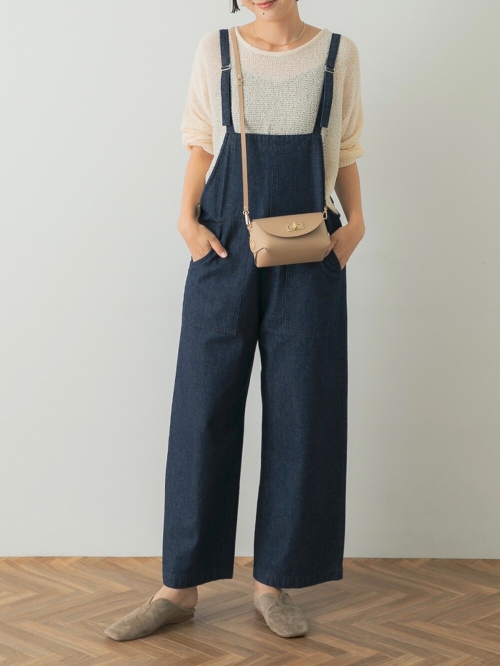 グレー系のスリッポン、ホワイト系のニット/セーター、ブルー系のサロペット/オーバーオールを着用したレディースの夏コーディネートの3枚目の写真