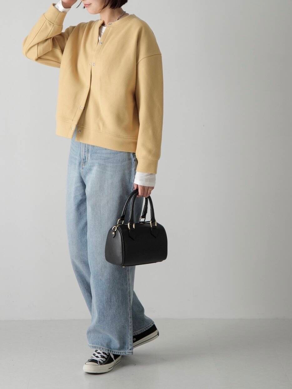 ブルー系のデニムパンツ、ホワイト系のTシャツ/カットソー、ブラック系のボストンバッグを着用したレディースの秋コーディネートの4枚目の写真