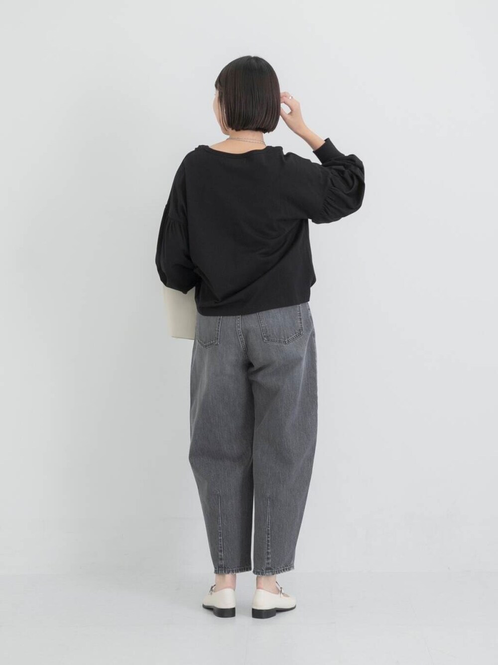 ベージュ系のショルダーバッグ、ホワイト系のその他シューズ、ブラック系のTシャツ/カットソーを着用したレディースの秋コーディネートの4枚目の写真