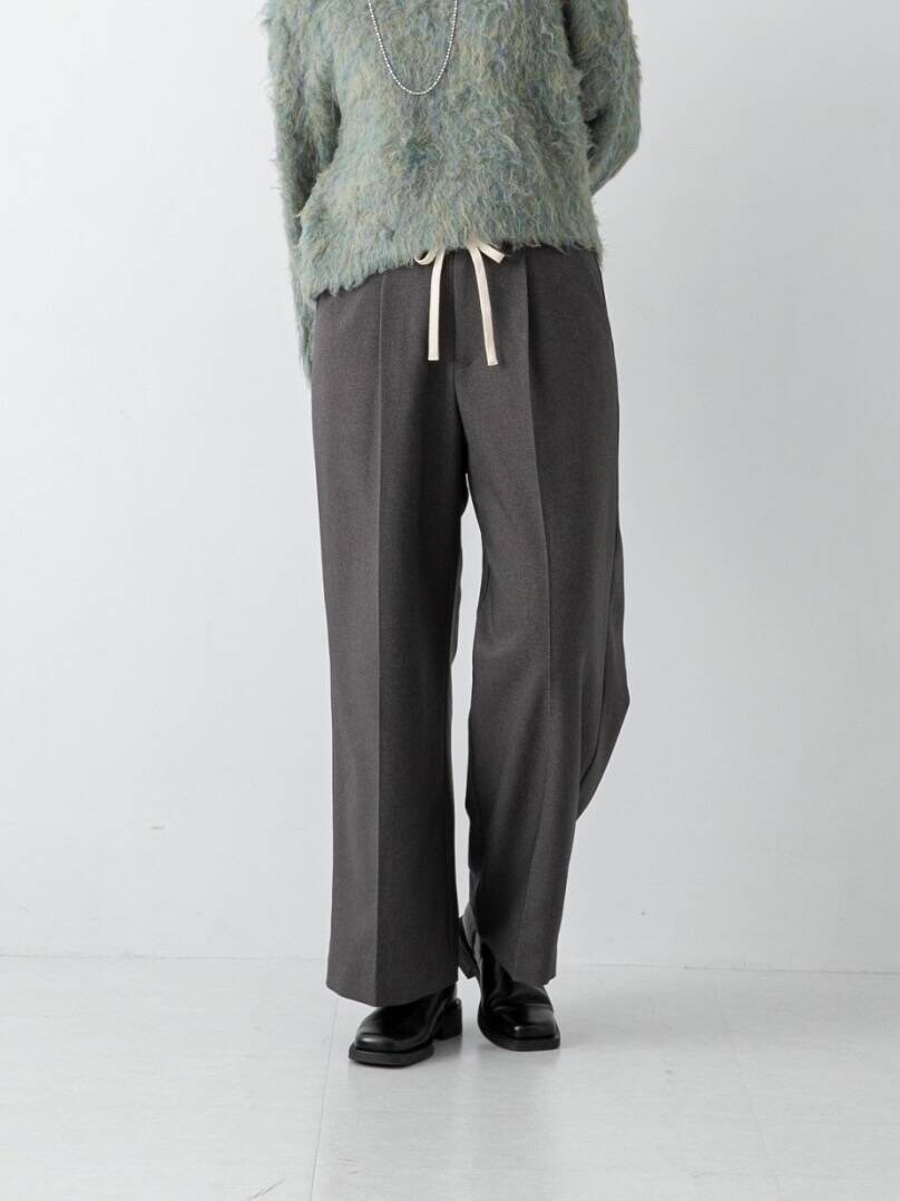 グリーン系のニット/セーター、グレー系のその他パンツを着用したレディースの冬コーディネートの3枚目の写真