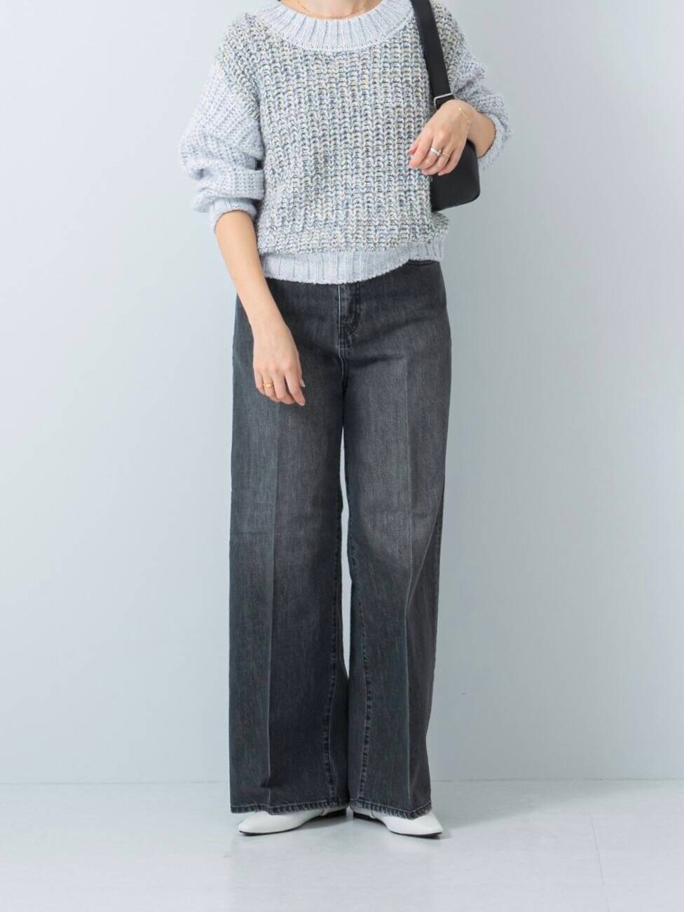 ブルー系のニット/セーター、ブラック系のデニムパンツを着用したレディースの冬コーディネートの5枚目の写真