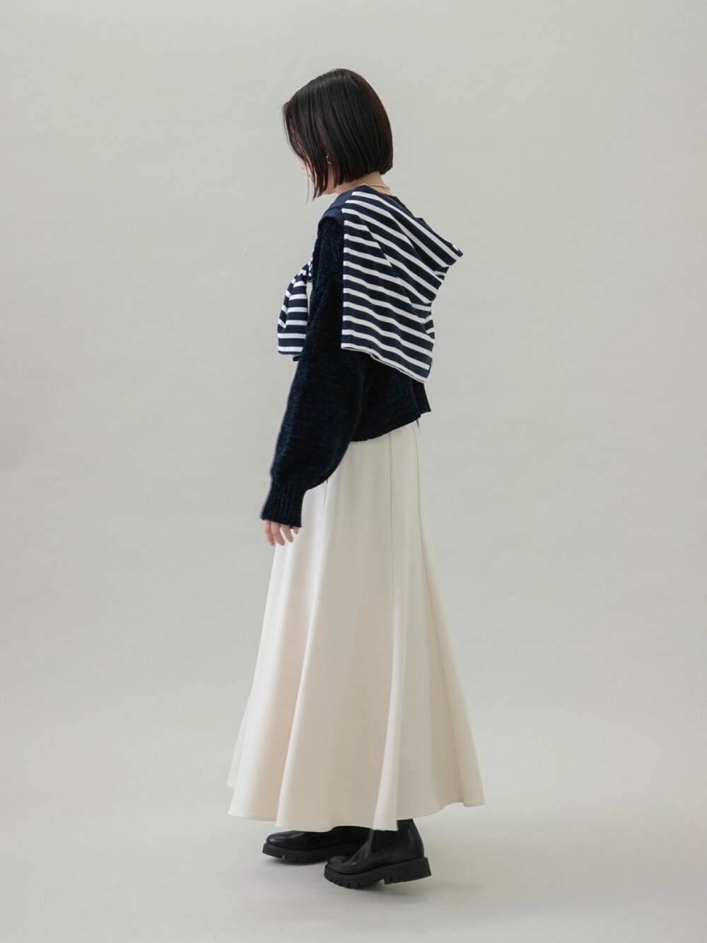 ホワイト系のスカート、ブルー系のTシャツ/カットソー、ブラック系のブーツを着用したレディースの秋コーディネートの3枚目の写真