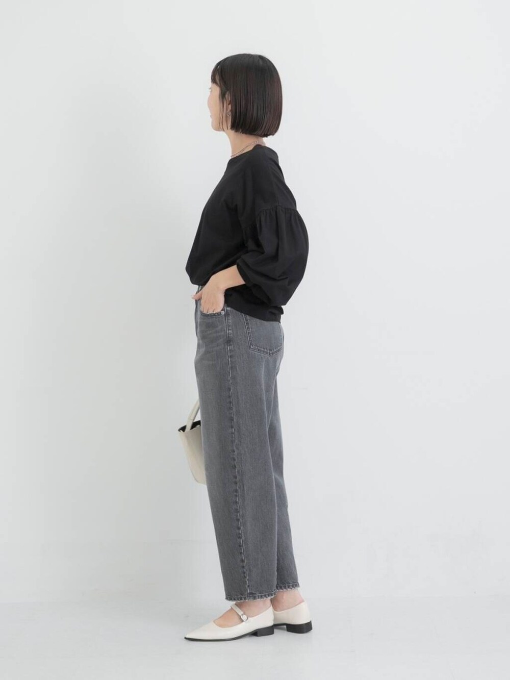 ベージュ系のショルダーバッグ、ホワイト系のその他シューズ、ブラック系のTシャツ/カットソーを着用したレディースの秋コーディネートの3枚目の写真