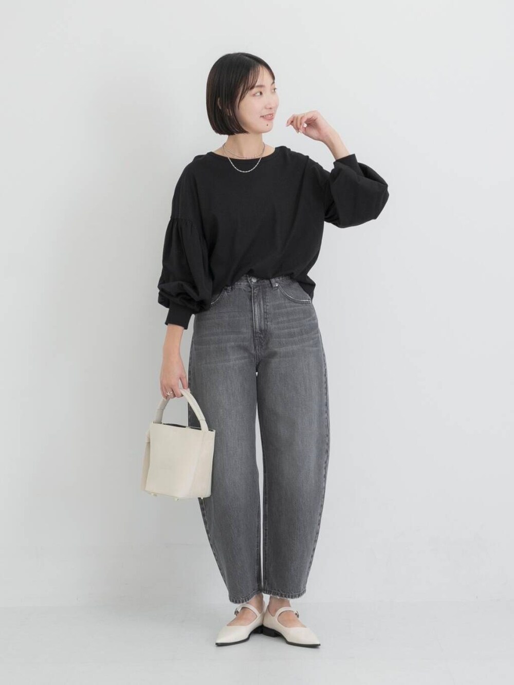 ベージュ系のショルダーバッグ、ホワイト系のその他シューズ、ブラック系のTシャツ/カットソーを着用したレディースの秋コーディネートの2枚目の写真