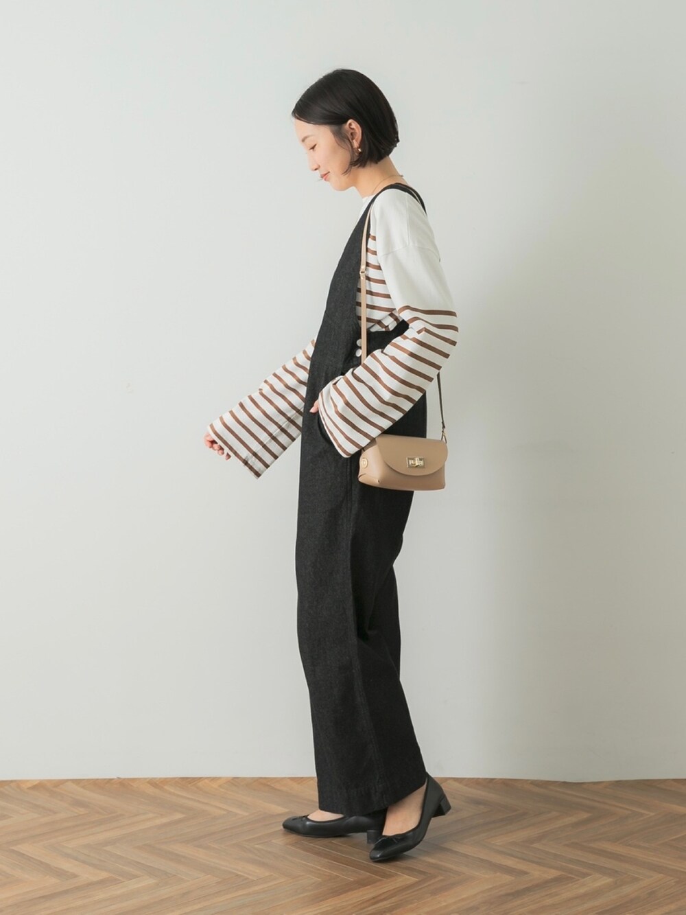 ホワイト系のTシャツ/カットソー、ブラック系のつなぎ/オールインワン、ベージュ系のショルダーバッグを着用したレディースの夏コーディネートの2枚目の写真