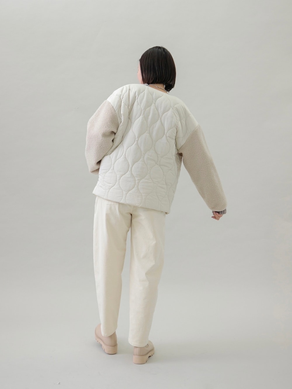 ベージュ系のニット/セーター、ホワイト系のその他パンツ、ベージュ系のブーツを着用したレディースの秋コーディネートの3枚目の写真